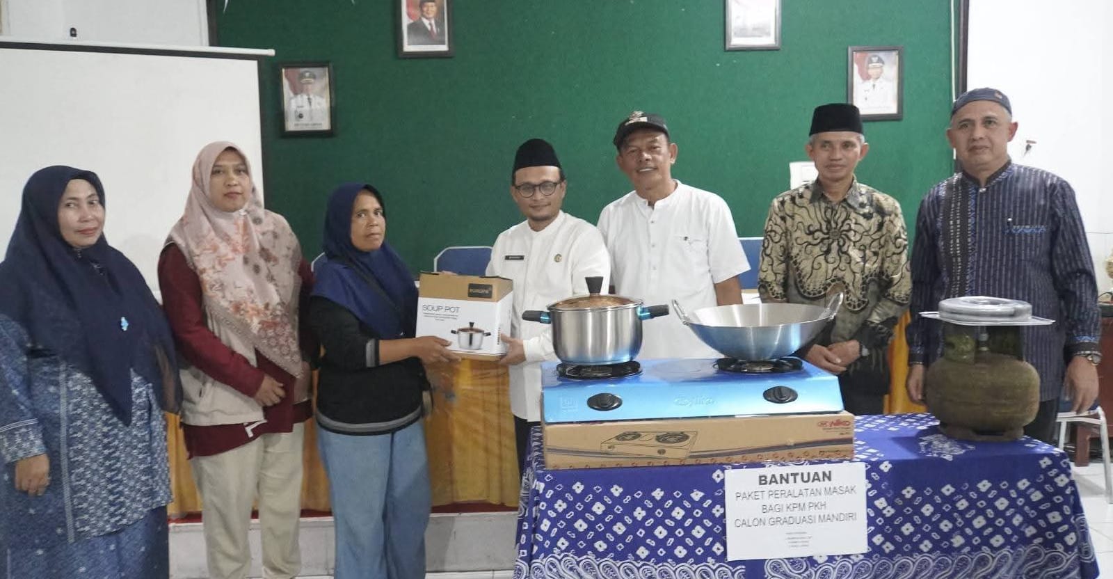 Penerima bantuan saat poto bareng jajaran Dinsos dan BAZNAS.